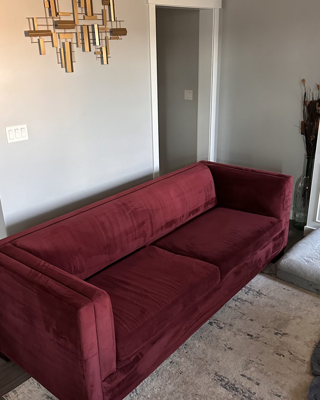 The same red velvet sofa after Softify cleaning, rich and vibrant